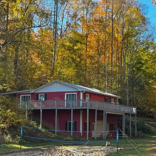 Charming red house surrounded by autumn trees at Asheville Recovery Center, a detox center in Charlotte.