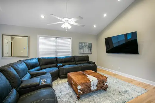 Spacious living room with sectional sofa in a sober living home in Charlotte.